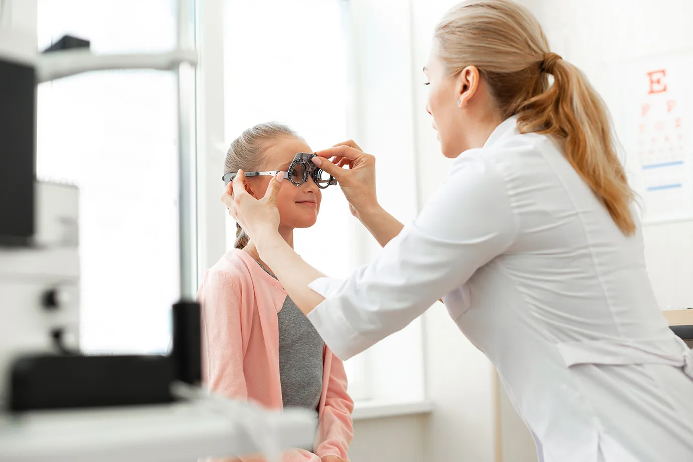 AdobeStock_271543151 EIne Augenärztin untersucht die Augen eines Mädchens