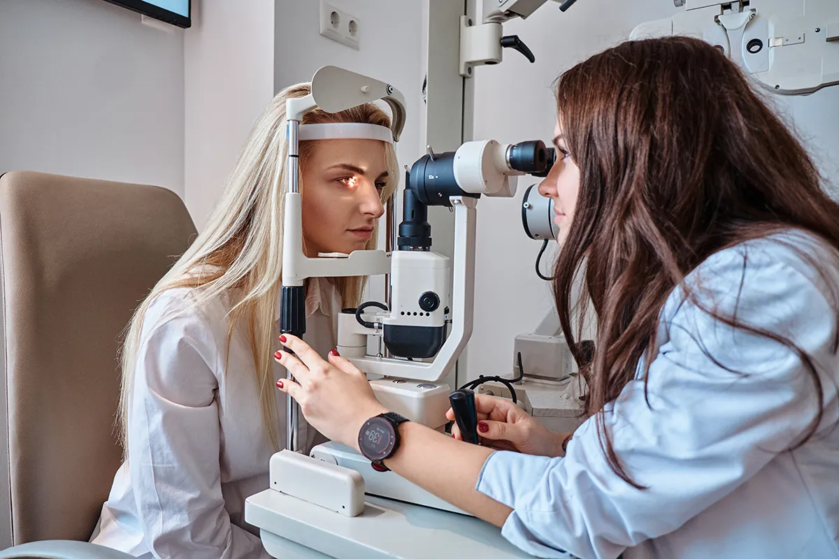 AdobeStock_300433339 Eine Augenärztin untersucht die Augen einer Frau